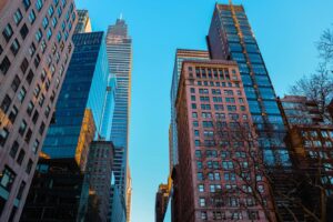Low angle view of skyscrapers against a clear sky in a bustling urban area.